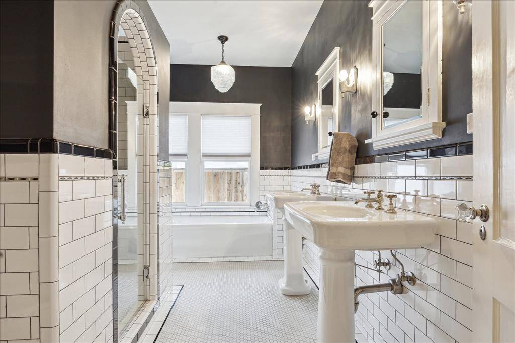 The Primary bath offers two pedestal sinks, separate shower and soaking tub. It has been fully restored to period.