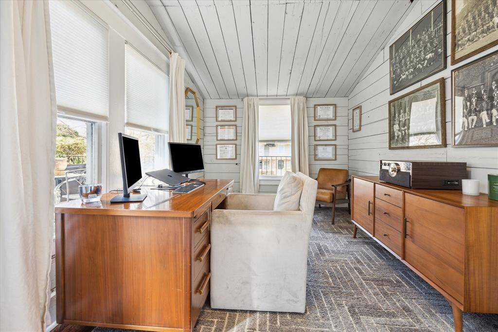 The quarters are currently used as an additional office space. It feature painted shiplap walls and views of the balcony living space. This space could be used as an in-laws quarters, office, or bonus room.  Complete with Central A/C, closet and a full bathroom.