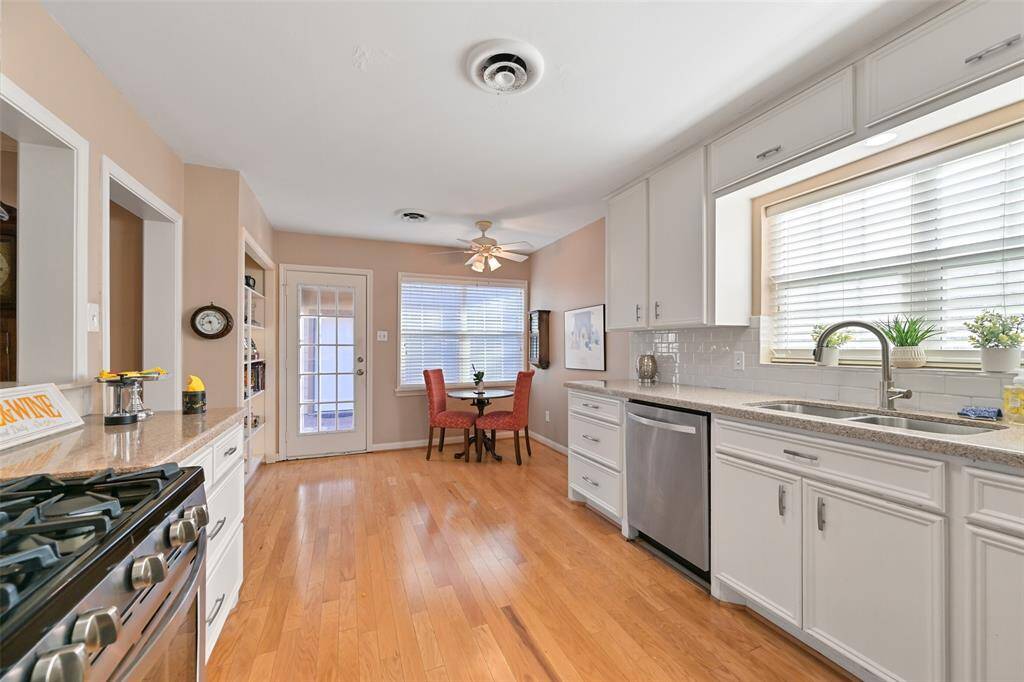 Natural light streams through large window above the double stainless steel sink.