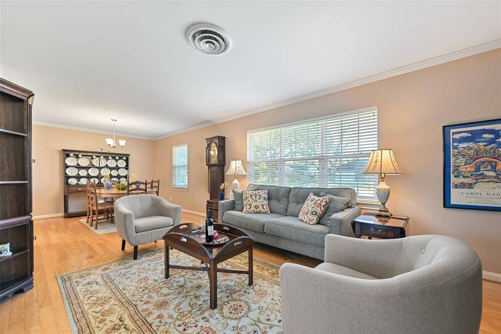 Warm neutral paint, crown molding and light engineered wood flooring enhance the space.