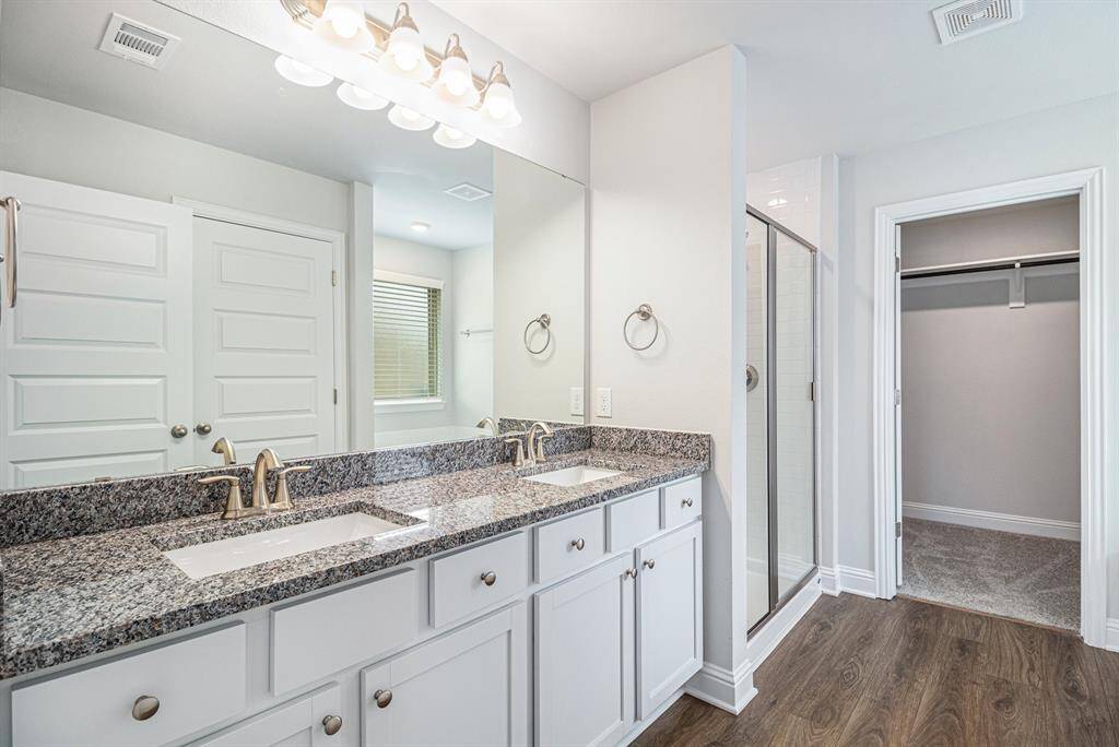 Primary Bathroom with Double Vanity Sinks and Separate Shower and Bathtub