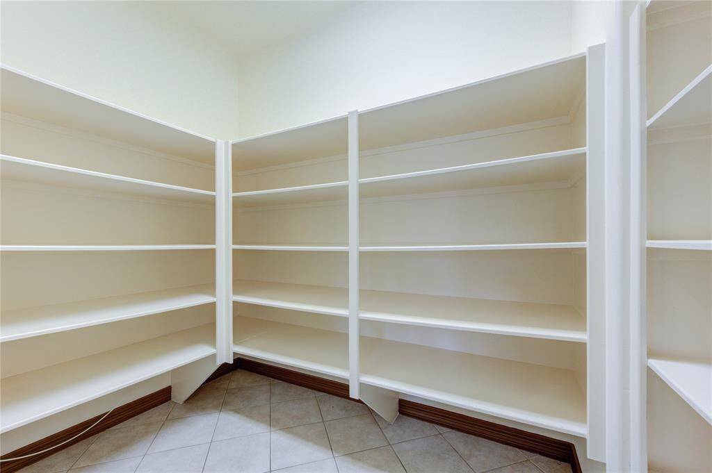 This is a spacious and modern open-concept game room, featuring rich wood flooring, dark cabinetry, ample natural light, for Family entertainment. (virtually staged)