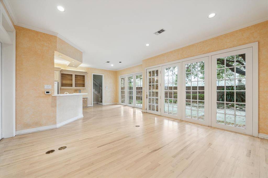 Family room photo looking towards kitchen and breakfast area shows the great flow between spaces as well as inviting views of the backyard and patio.  You can see the back staircase through the doorway.