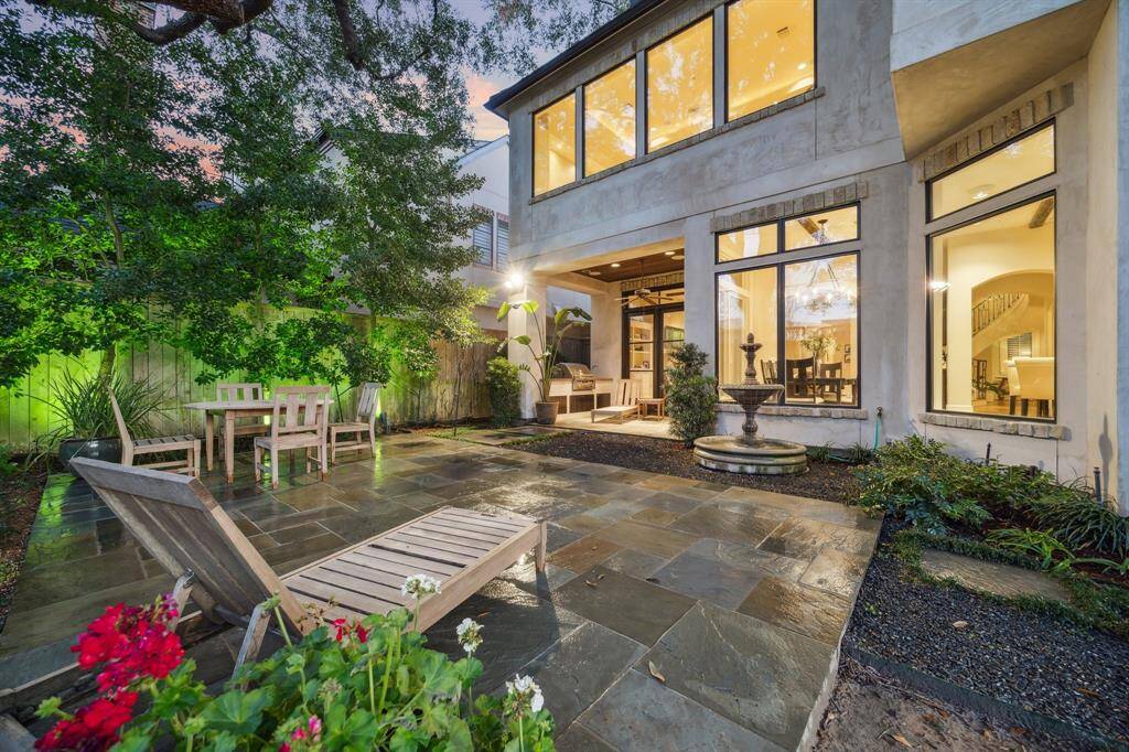 Large slate deck and water feature in pool-size yard under the canopy of a magnificent oak.