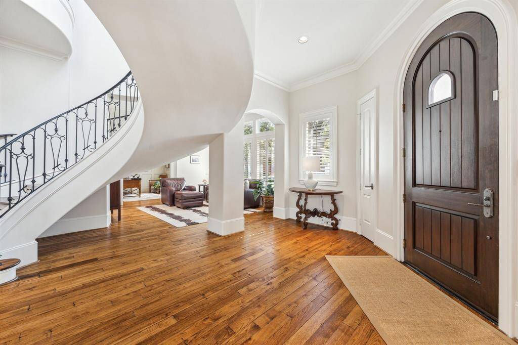 This view is of the foyer toward formal living area and on to study. Most windows have transoms and plantation shutters. The stairwell is a stunning architectural feature that creates interesting views from the foyer, formal living, and formal dining rooms.