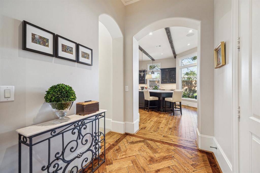 View toward kitchen. Side entry and garage are to the left. Downstairs portion of elevator shaft is on the right. Thresholds from living/entry area to kitchen/family rooms are embellished with beautiful inlaid framed herringbone accents between rooms. Doors throughout the house are 2-panel solid core.