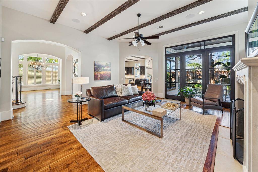 View of family room toward dining room, kitchen and backyard patio access. Glass wall patio access is on the right. Kitchen threshold is just to left of patio. The threshold on the right is view toward formal dining room. Stairwell is just on other side of threshold to the left.