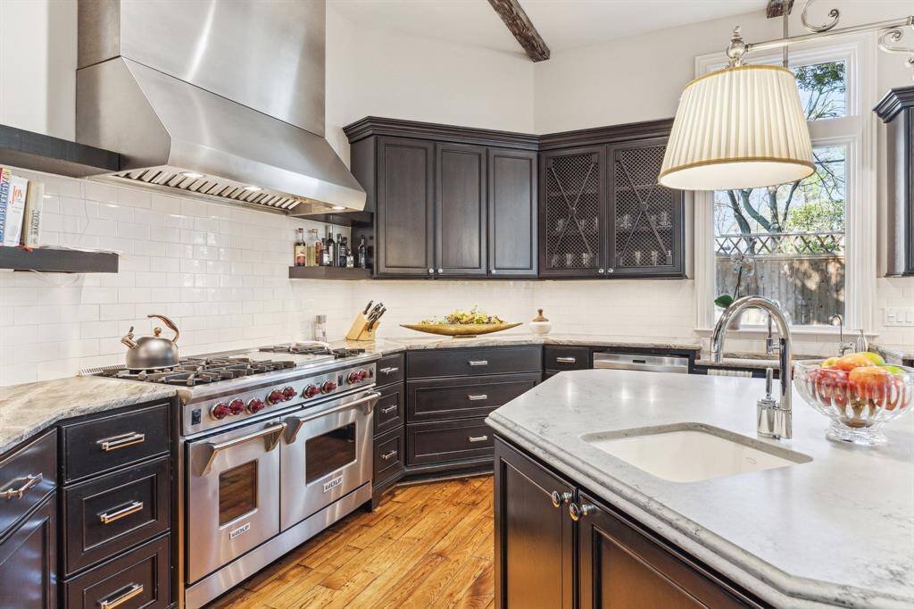 Contrasting cabinet colors and different stone-surfaced island and cabinet countertops create a uniquely inviting area for casual dining and entertaining. The appliances are stainless steel: Sub-Zero, Wolfe and top-of-the-line Kenmore. Fabulous kitchen for entertaining and serious culinary projects. Well equipped space includes great storage, abundant work space for the most ambitious gourmand and more floor-to-ceiling glass overlooking soothing water feature and gorgeous backyard.