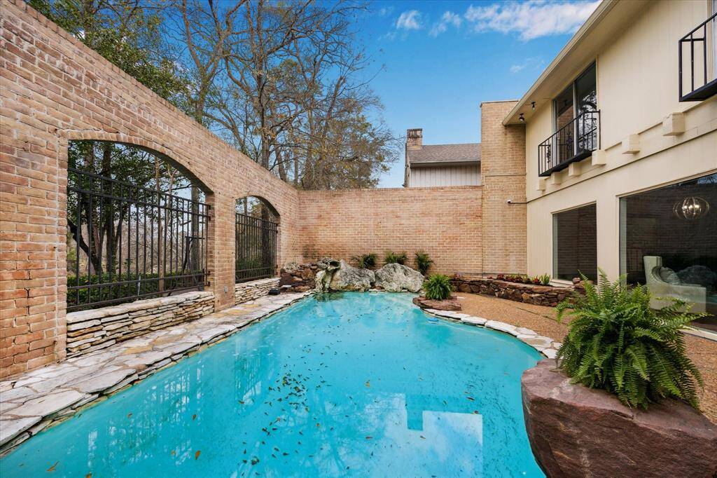Discover your private oasis with this stunning outdoor pool, beautifully enclosed by timeless brick walls for ultimate seclusion.