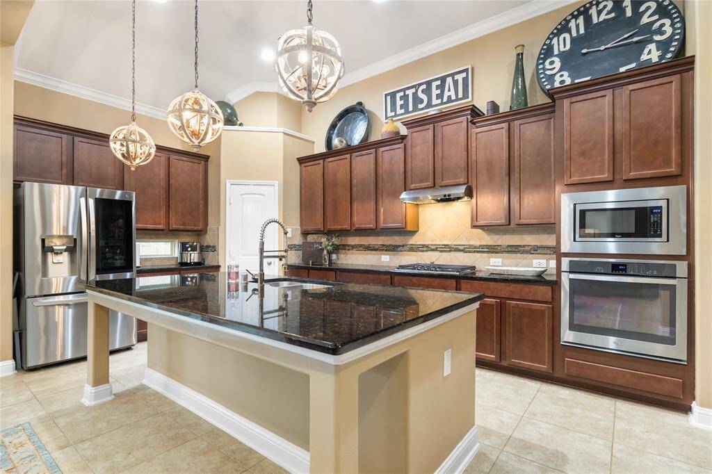 Lovely granite counters, 42" cabinets, trendy pendent lighting, and stainless steel appliances make this kitchen as beautiful as it is functional.
