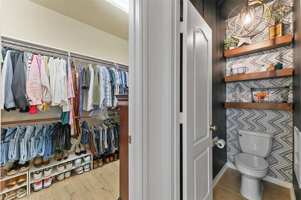 The walk-in closet adds ample storage space, completing this beautiful bathroom.