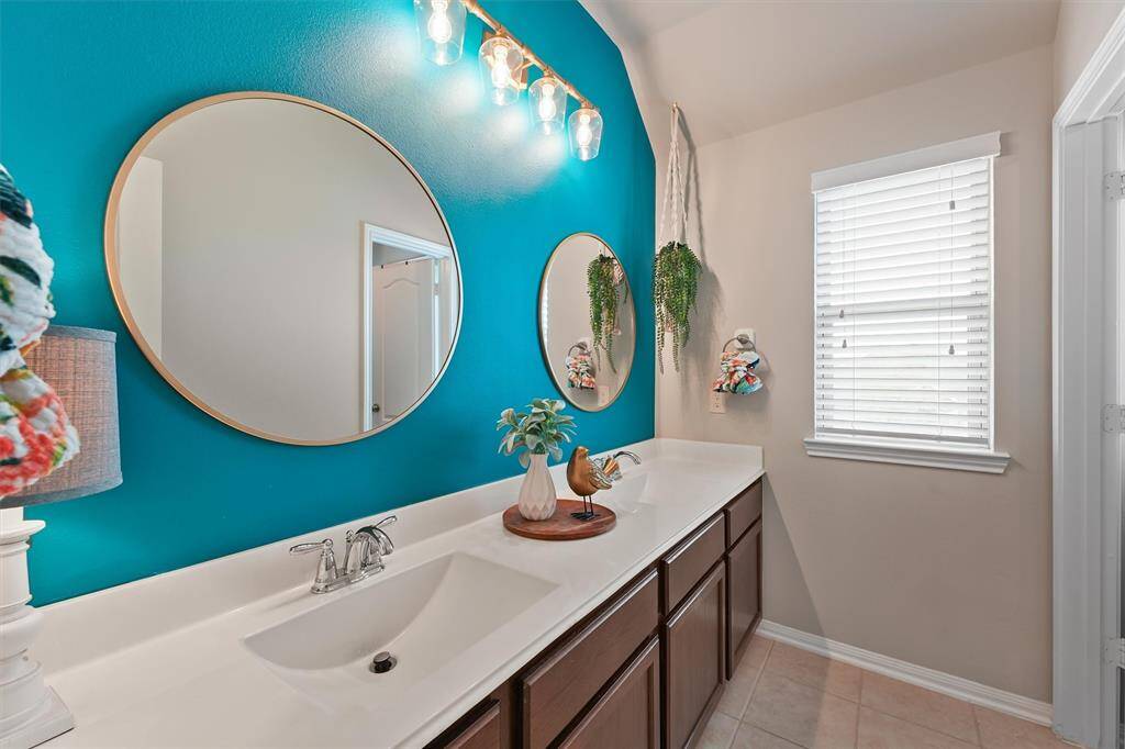 The secondary bathroom blends functionality with style. The sleek white countertop offers a versatile foundation, effortlessly complementing any décor while adding a bright, fresh touch to the space.