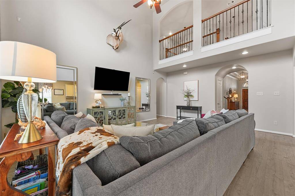 The kitchen seamlessly opens up to the family room and breakfast nook, creating a perfect flow for everyday living and entertaining. Custom pendant lights hang above the island, while a stunning chandelier adds elegance to the space.