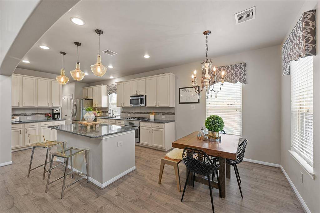 The kitchen features beautiful custom cabinetry and sleek granite countertops, making it both functional and stylish for all your culinary needs.