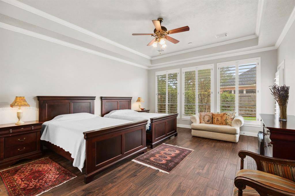 The grand primary suite is elevated by floor-to ceiling-windows & high tray ceilings.  A full glass door leads to the backyard & patio.