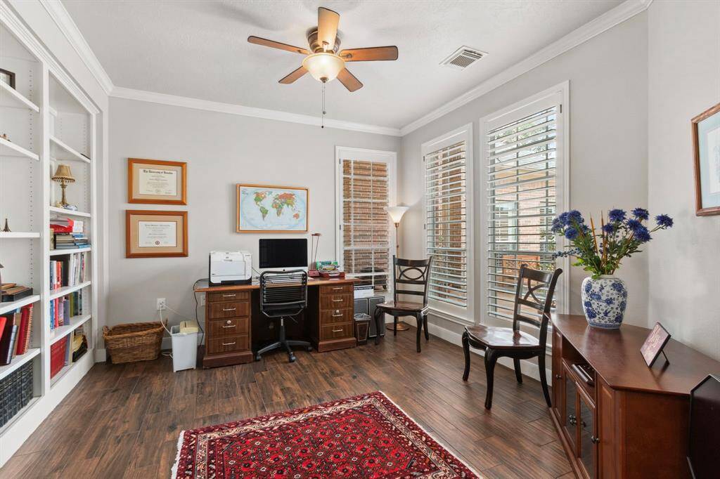 Double French doors open to a spacious office/study that features built-in shelving.  The large windows offer views to the private courtyard area & front gate.