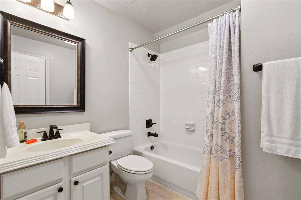 The full bathroom upstairs in the main house is light & bright, offering a tub/shower with white tile surround.