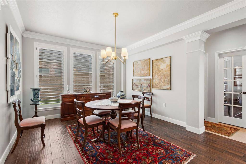 The formal dining room is open to the foyer & features large windows with plantation shutters & wood tile plank flooring.  To the right you see the French doors that lead to the office/study.