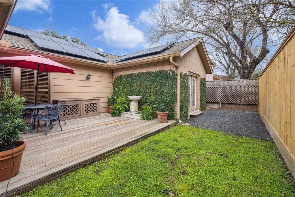 The rear backyard features an expansive patio. Additional exterior highlights include: solar panels (2022), new perimeter fence (2024), sprinkler system, mature landscaping, and new live oak trees (3) in the front yard (2024).