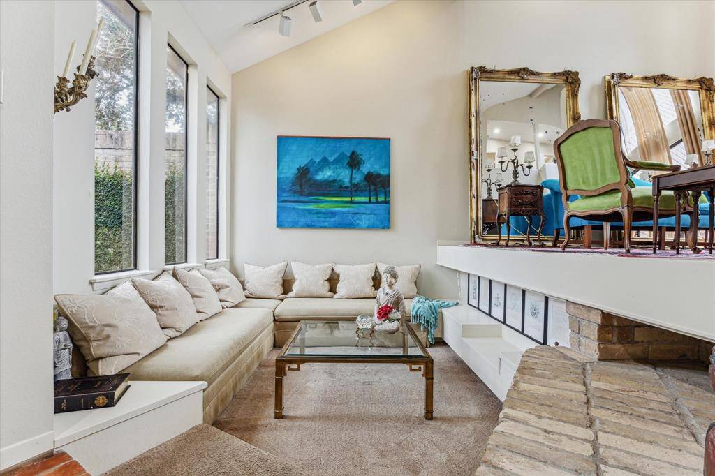 Step down into a cozy recessed lounge, perfect for intimate gatherings or relaxing, offering a warm and inviting atmosphere with a touch of architectural charm.