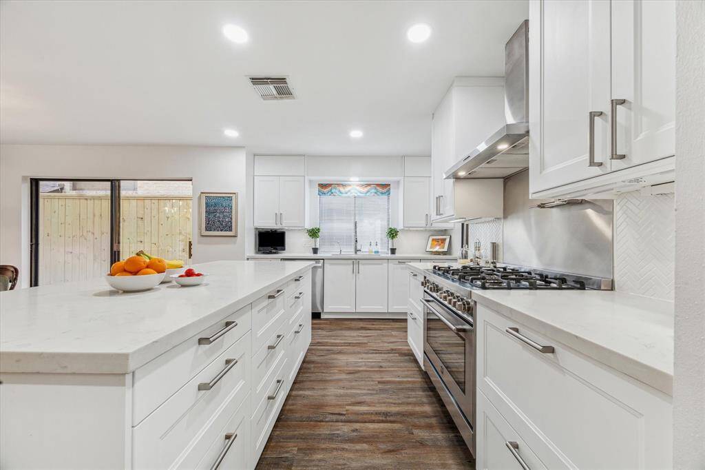 Appliances include stainless steel dishwasher, Roma 6-burner gas range with a stainless steel backsplash, pot filler and coordinating vent hood.