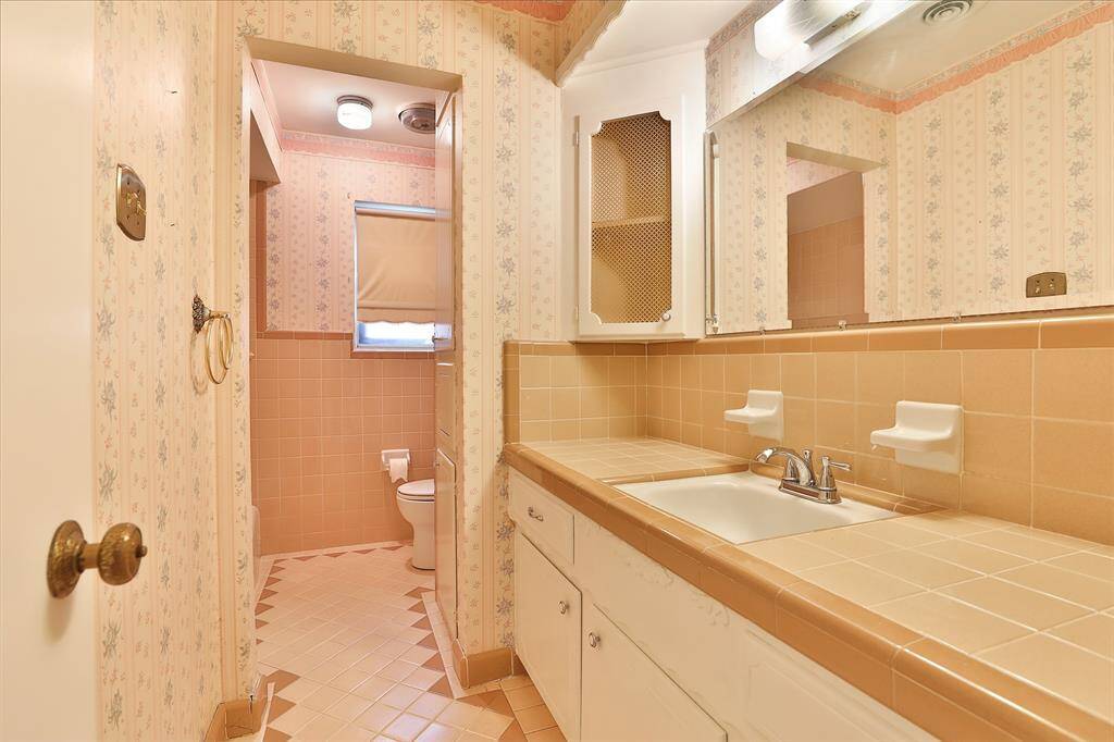 Hall bath features tile, and tub with shower!  Don't you just love the little corner storage cabinets!
