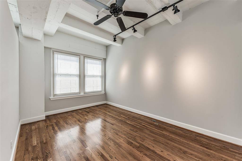 The second bedroom is generously sized, making it a comfortable retreat providing ample space for various furniture arrangements. Two large windows fill the room with natural light.