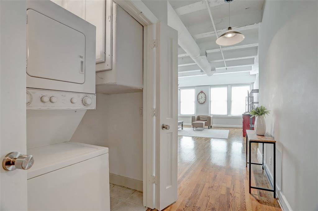 Located in the foyer, the dedicated laundry space features a stacked washer and dryer, which will convey with the sale of the property, adding convenience to everyday living.
