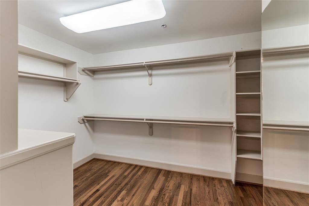 The walk-in closet is generously sized, offering plenty of room for storage. Built-in cabinets provide a practical solution for keeping everything neatly organized, making it easy to store clothing, shoes, and accessories while maintaining a clutter-free space.