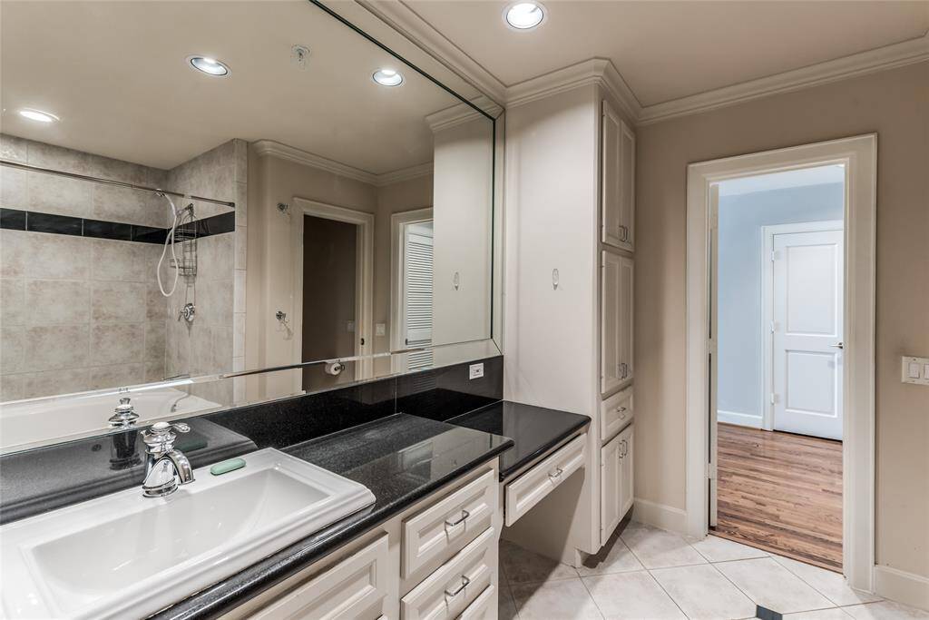 Another view of the vanity area highlights its functionality and style. Take note of the abundant cabinetry, providing plenty of storage to keep your essentials organized and easily accessible.