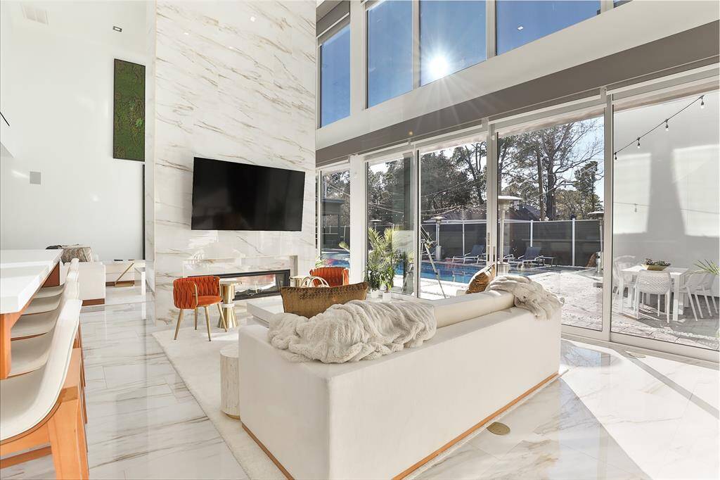 The see through remote fireplace gives separation to the lanai inspired creation outside. Each wall shade was custom fit and operated through Savant smart home technology. The West wall of UV light protecting windows brings the outside in to further the Zen feel of the home.