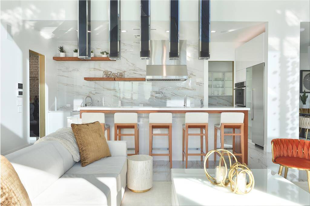 The plated polished chrome canopy pendants with smoky gray acrylic shades were curated from the mind of the seller and custom made to fit the space giving the allure of an opulent hotel.