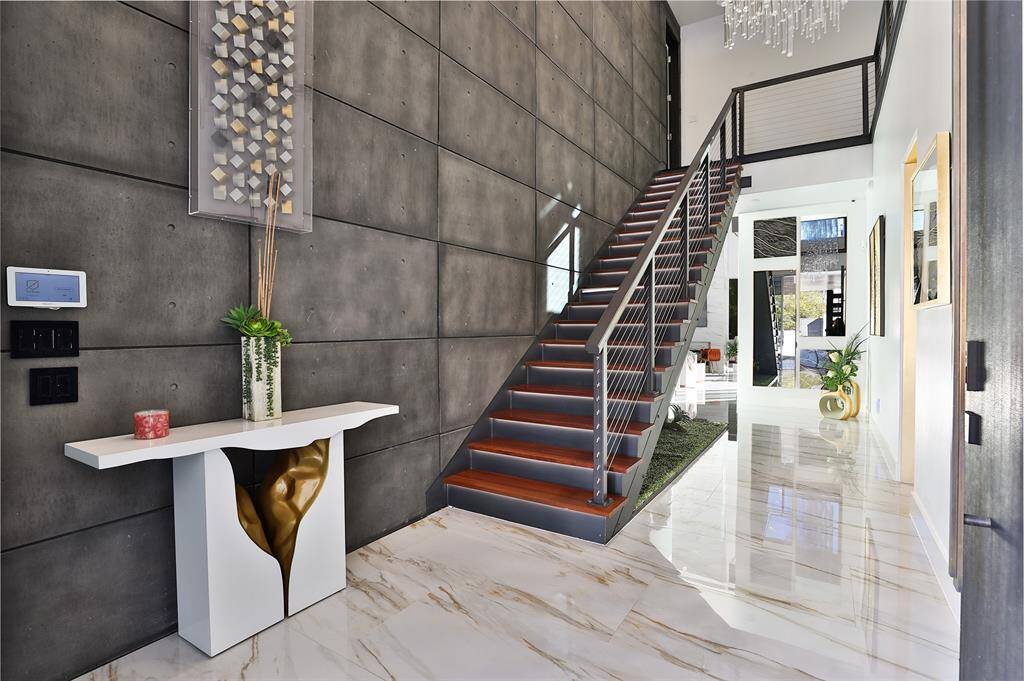 The sleek lines of the opulent 24x48 floor tiles, mixed with the masculine concrete look wall accent gives the  perfect pairing of light and dark.