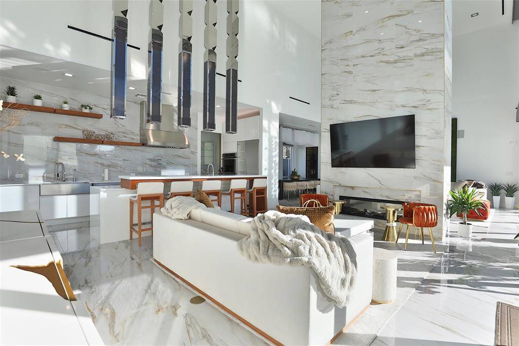 Soak in the elegance of the family room with crisp, clean lines, a soaring dual sided 20' fireplace and hidden modern home automation.