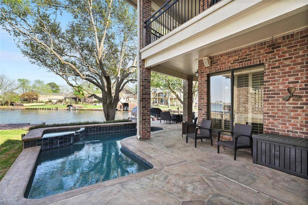 Relax by the tranquil pool on this inviting patio, perfect for enjoying stunning waterfront views and outdoor gatherings.