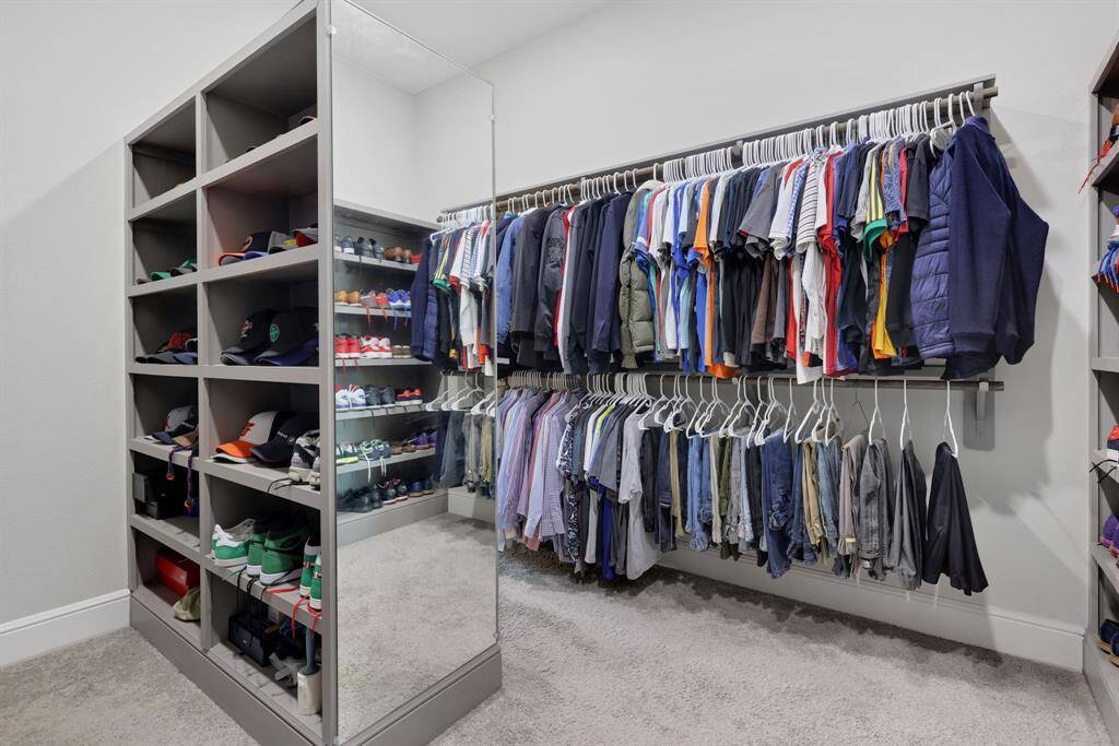 Spacious walk-in closet featuring ample shelving for shoes and accessories, plus extensive hanging space for clothes.