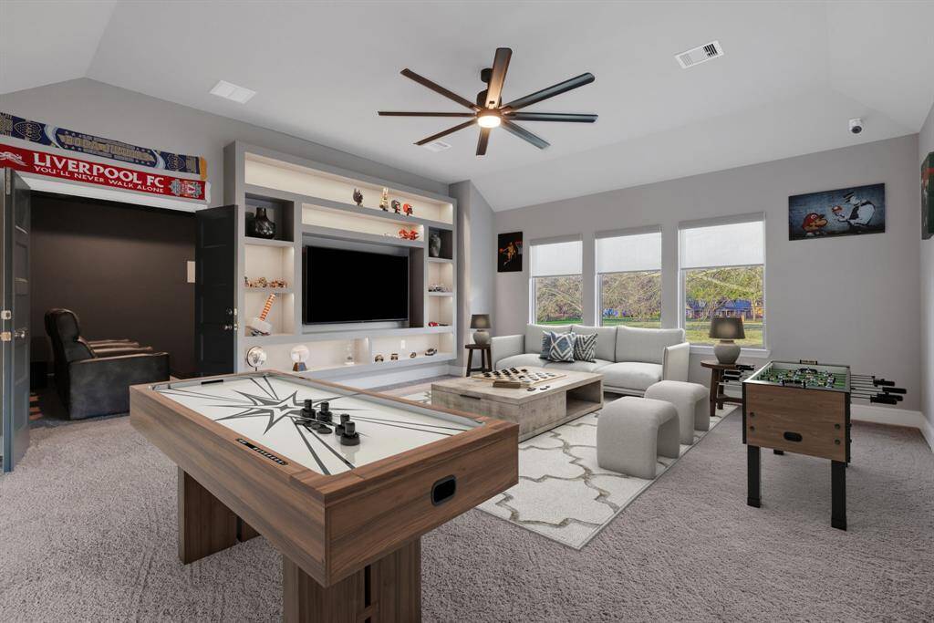 This spacious game room features built-in shelves with customer under lighting.