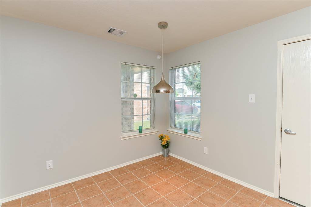 Bright breakfast nook with two large windows offering abundant sunlight and fresh air.
