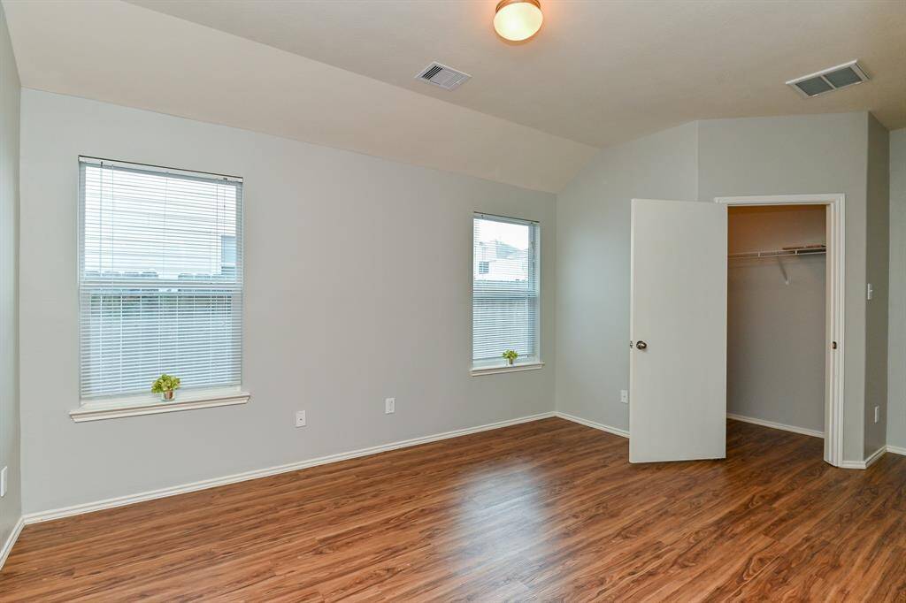 Spacious primary bedroom with abundant natural light and a walk-in closet.