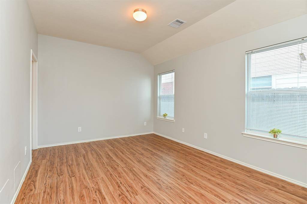 Inviting primary bedroom with abundant natural light and elegant flooring.