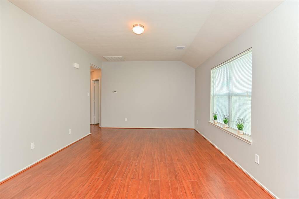 Bright living room with high ceilings and laminate floors.