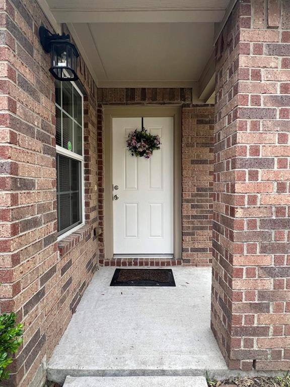 Welcome to your new home! This charming entrance, adorned with a lovely wreath, invites you into a warm and welcoming space.