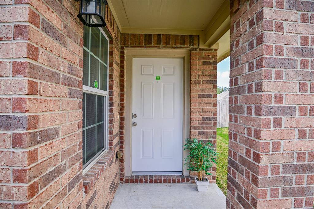 Charming front entrance with a covered brick patio.