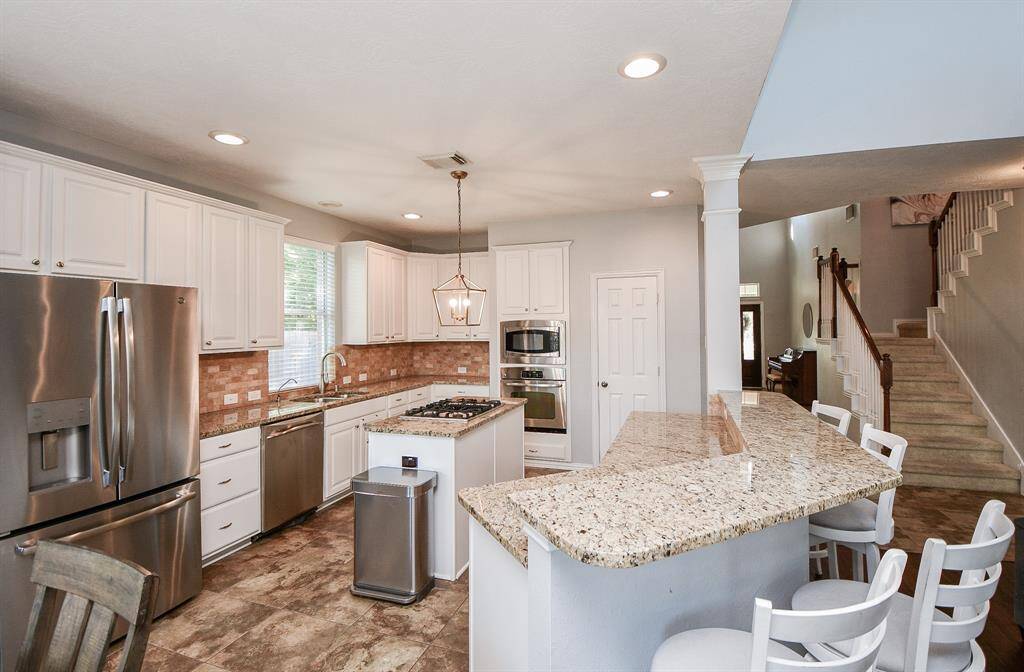 Spacious kitchen with expansive granite countertops and abundant cabinet storage.