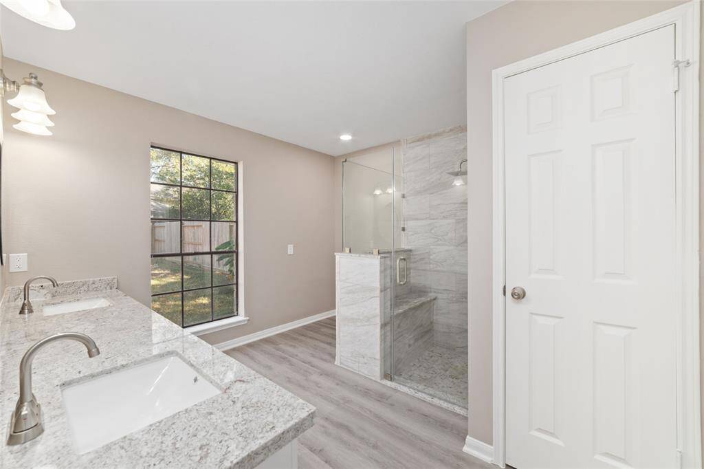 Experience decadence and relaxation in the primary ensuite bathroom’s spacious frameless shower with bench seat and rain shower head. Decorator’s nook provides the perfect alcove for a glass and wood bathroom armoire or vanity.