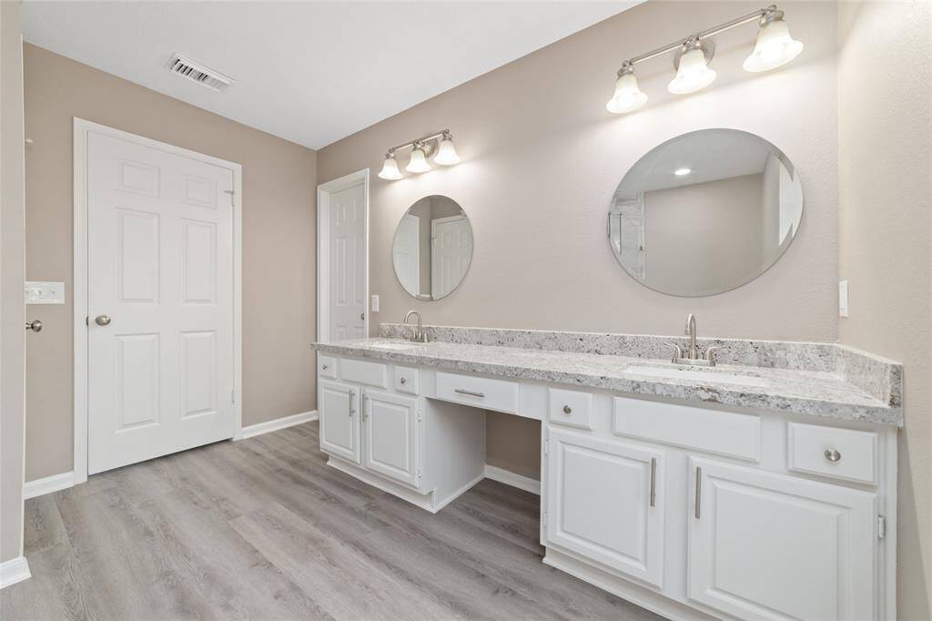 The stress-free ensuite easily accommodates two people getting ready for the day with generous counter space, twin sinks, and separate drawers and cabinets.