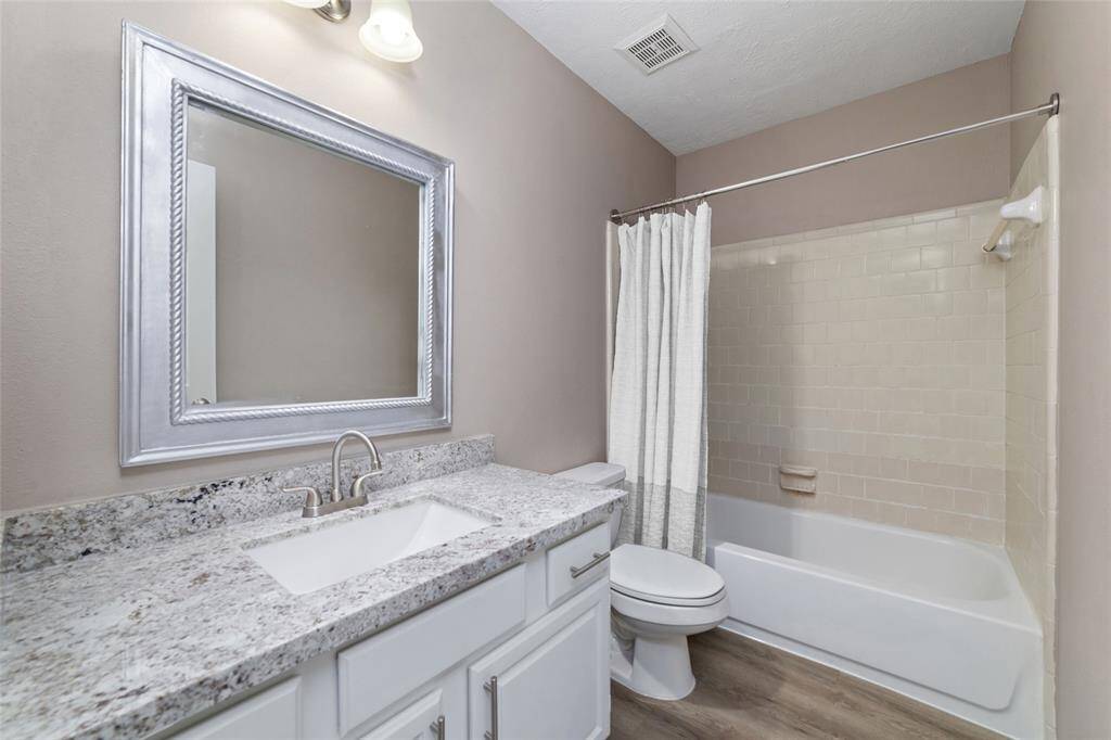 Upstairs bedrooms share a full bath with granite countertop and luxury vinyl plank flooring.