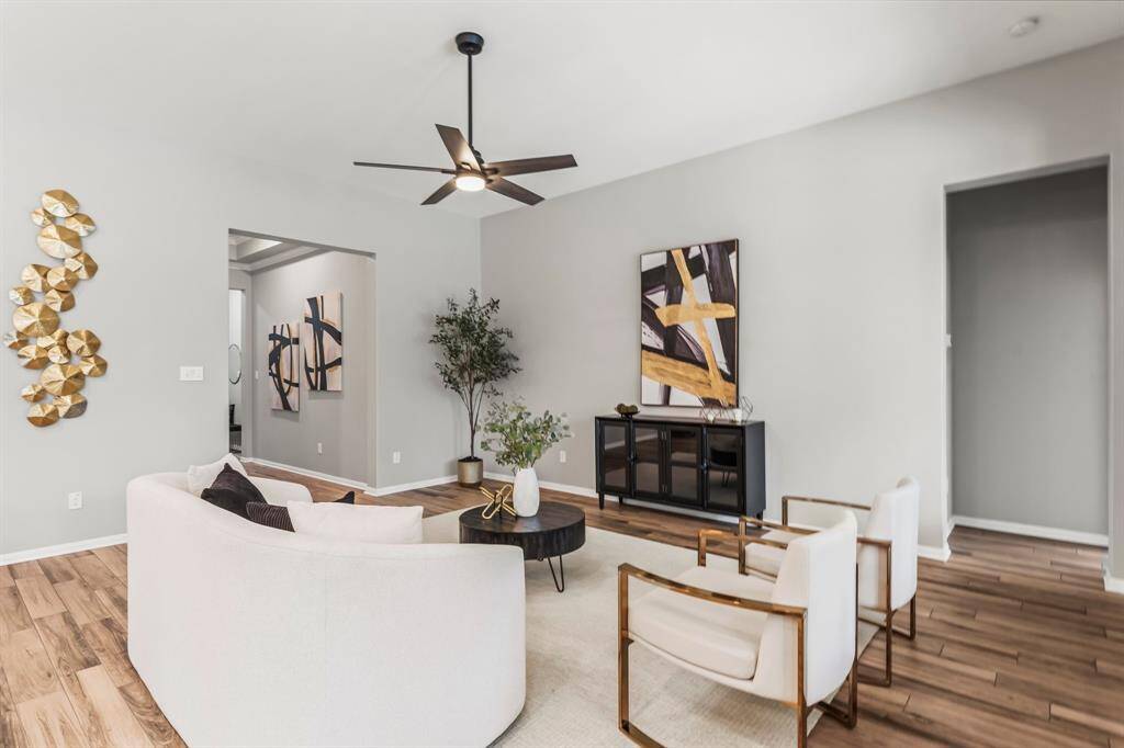 This open-concept living space features a modern kitchen with an large quartz island, sleek shaker style cabinetry, and pendant lighting.