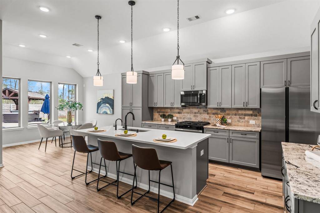 This kitchen highlights its beautifully updated quartz island, complemented by updated appliances and modern pendant lights.