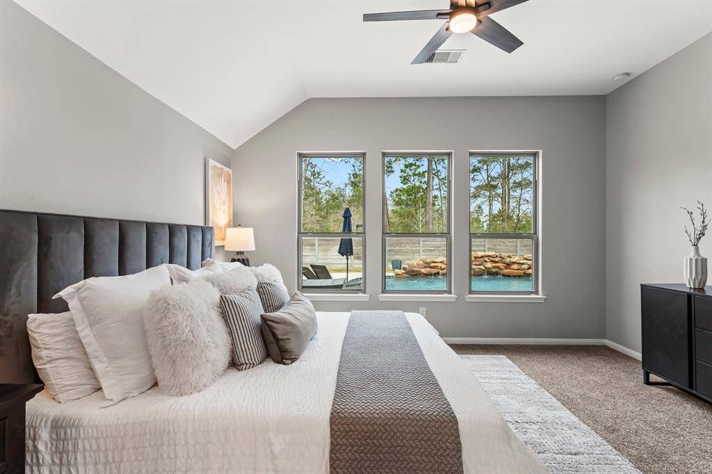 This spacious primary bedroom features high ceilings, large windows with backyard and pool views, and abundant natural light. Recently updated carpet adds a fresh touch.